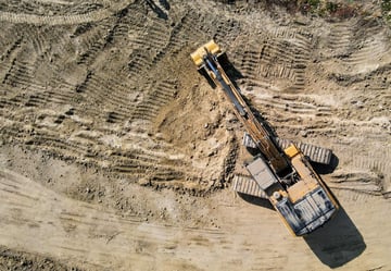 black and yellow heavy equipment on brown rock formation during daytime_edited